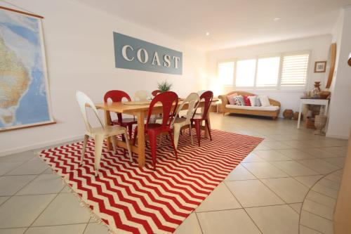a dining room with a table and chairs on a rug at Jubilee Apartment 10 2 Paragon Ave SWR in South West Rocks