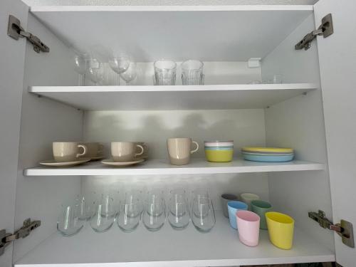 a shelf with cups and utensils in a kitchen at BELI KAMEN Vikendica in Besenovacki Prnjavor