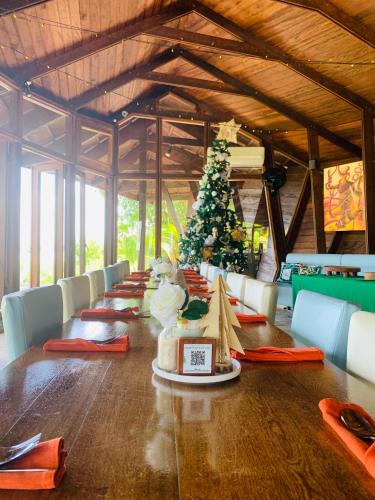 a long table with a christmas tree in a room at Houttuyn Wellness River Resort in Paramaribo
