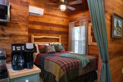 a bedroom with a bed in a room with wooden walls at Riley's Retreat Cabin in Broussard
