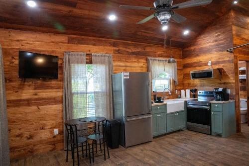 a kitchen with a refrigerator and a table in it at Riley's Retreat Cabin in Broussard