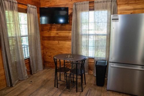 a kitchen with a small table and a refrigerator at Riley's Retreat Cabin in Broussard