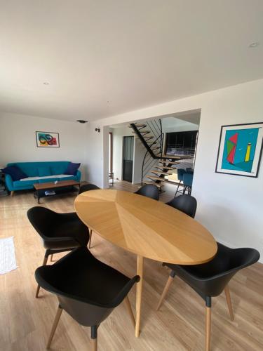 a living room with a wooden table and chairs at Vue Mer Très belle plage à pied Maison proche Lesconil Loctudy in Loctudy