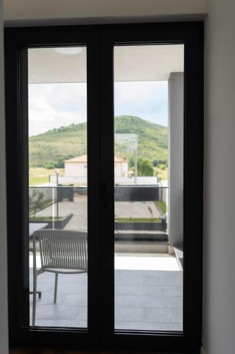 a sliding glass door with a bench on a balcony at Villa H in Blagaj