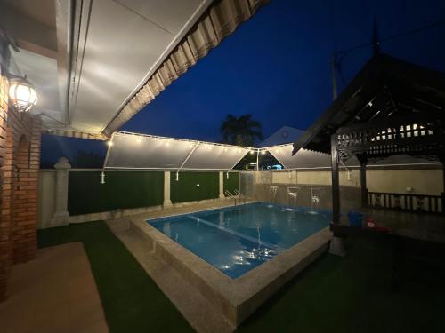 a swimming pool in a house at night at Mawar 23 Chendering with Private Pool in Kuala Terengganu