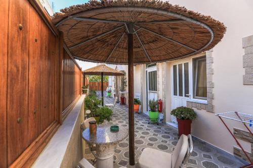 a patio with a table and an umbrella at Sweet Home in Karterados