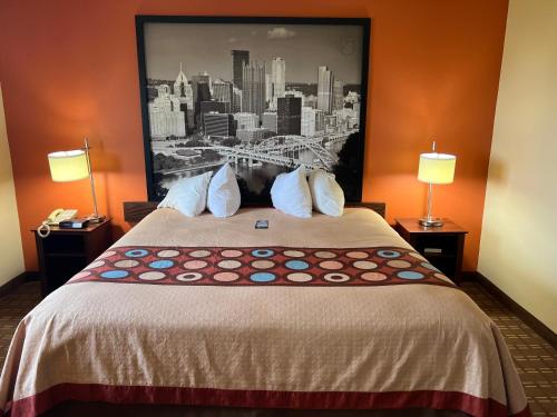 a hotel room with a bed with a picture on the wall at Super 8 by Wyndham Altoona in Altoona