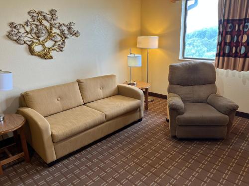 a living room with a couch and a chair at Super 8 by Wyndham Altoona in Altoona