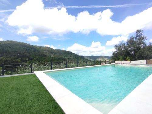 a swimming pool in the middle of a yard at Quinta dos Picarotos in Vila Nova de Ceira