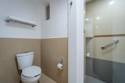 a bathroom with a toilet and a glass shower at Hotel La Venta Inn Villahermosa in Villahermosa