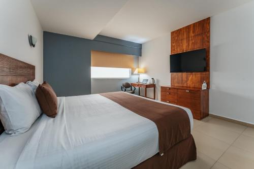 sypialnia z dużym łóżkiem i telewizorem w obiekcie Hotel La Venta Inn Villahermosa w mieście Villahermosa