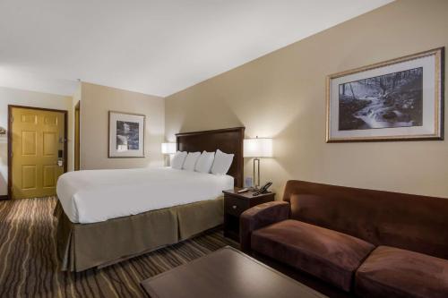 Best Western Cottage Grove Inn في كوتج غروف: غرفة فندق بها سرير وأريكة