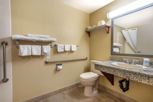 a bathroom with a toilet and a sink and a mirror at Best Western Strathmore Inn in Strathmore