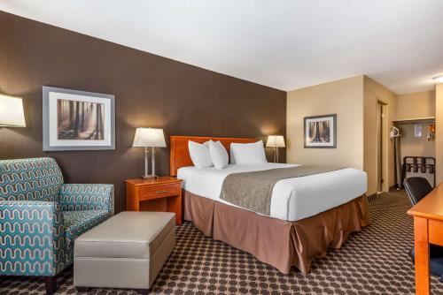a hotel room with a bed and a chair at Best Western Strathmore Inn in Strathmore