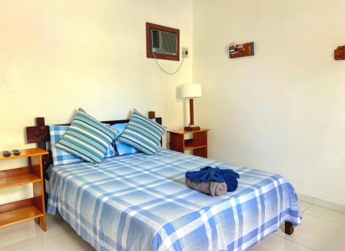 a bedroom with a blue and white bed with a night stand at Pousada Suites Nova Mar Ilhabela in Ilhabela