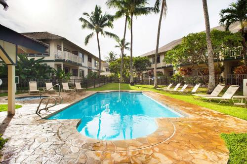 a swimming pool at a resort with palm trees at Aston At Poipu Kai in Koloa