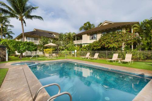 a swimming pool in front of a house at Aston At Poipu Kai in Koloa