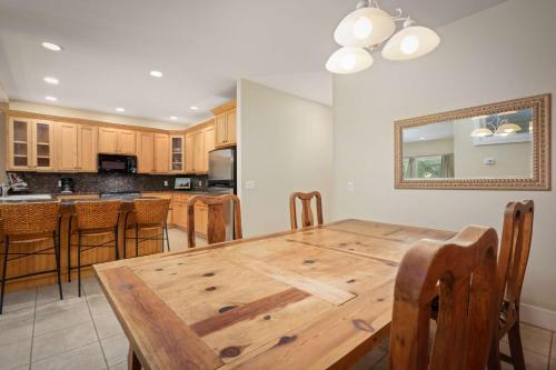 a dining room and kitchen with a wooden table and chairs at Aston At Poipu Kai in Koloa