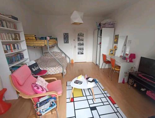 un salon avec un lit et une table dans l'établissement Grande chambre chez l'habitant dans hypercentre piéton, à Quimper