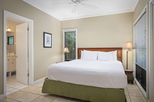 a bedroom with a large white bed and a bathroom at Aston At Poipu Kai in Koloa