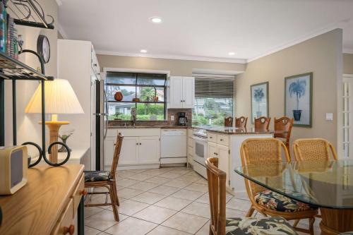 a kitchen with a table and chairs and a glass table at Aston At Poipu Kai in Koloa