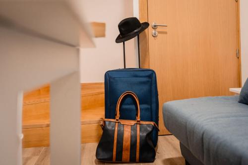 a blue suitcase sitting in a room next to a bed at Houses São Pedro in São João da Pesqueira