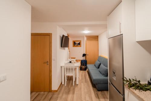 a living room with a blue couch and a table at Houses São Pedro in São João da Pesqueira