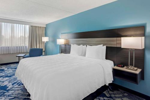 Best Western Rutgers University Hotel في إيست برونزويك: سرير أبيض كبير في غرفة الفندق