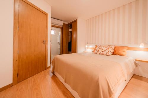 a bedroom with a bed and a wooden door at Houses São Pedro in São João da Pesqueira