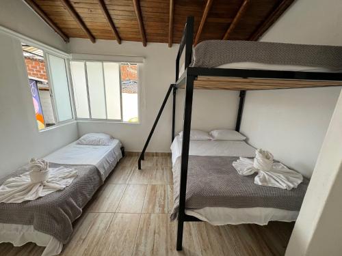 two bunk beds in a room with two windows at La Madriguera in Guatapé