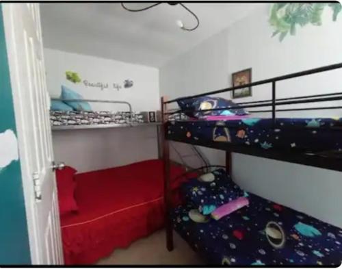 a bedroom with two bunk beds and a red bed at Annie Felise Transient House in San Pablo