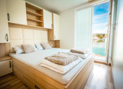 a bed in a room with a large window at Floating Sea House Panther Superior in Portorož