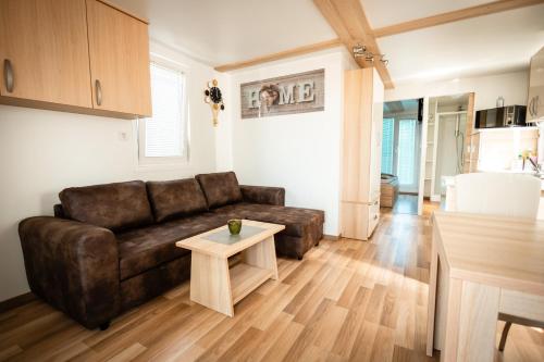 a living room with a brown couch and a table at Floating Sea House Panther Superior in Portorož