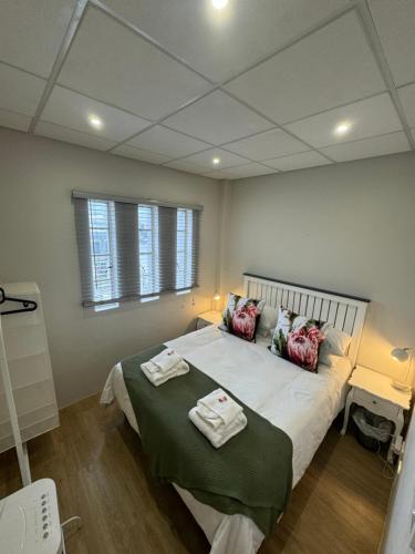 a bedroom with a large bed with towels on it at Protea in Paarl