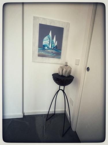 a corner of a room with a table with a picture at Appartamento Miro' Fine Living in Alghero