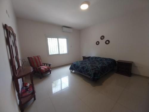 a bedroom with a bed and a chair at Duplex Yrigoyen B in San Juan
