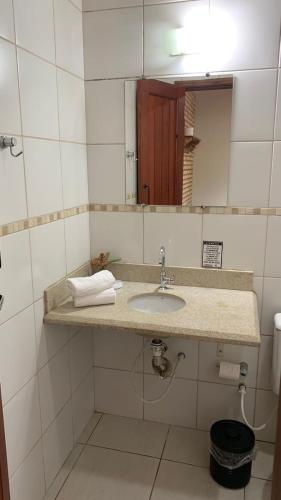 a bathroom with a sink and a mirror at Cheiro de Mato Pousada in Bonito