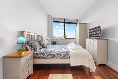 a bedroom with a bed and a window at Wimbledon Two Bedroom Luxury Stays - Central London in London