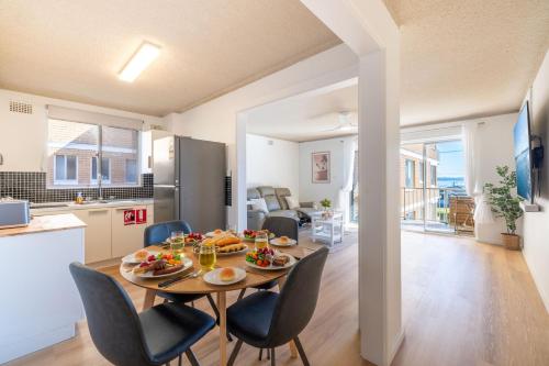 a dining room and kitchen with a table and chairs at Yarramundi, 7-47 Magnus St - spectacular views in the heart of Nelson Bay in Nelson Bay