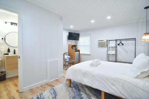 a white bedroom with a bed and a desk at Showboat Hotel in Himrod