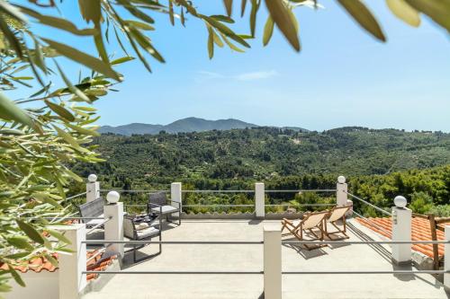a balcony with chairs and a view of the mountains at The Mountain Majesty in Skopelos Town