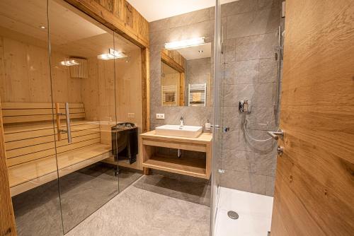 uma casa de banho com um lavatório e um chuveiro em AppartMO - Zillertal Arena, Hohe Tauern, Salzburgerland, Krimml, Hochkrimml em Krimml