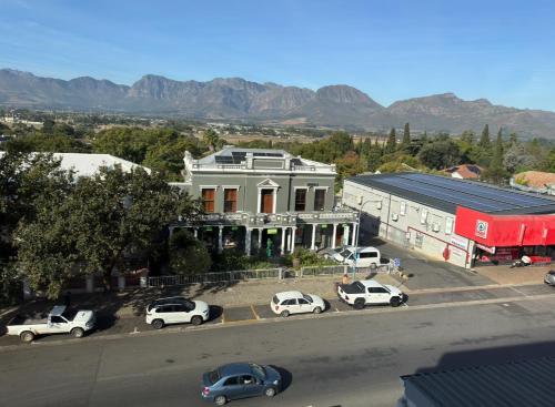 a large white building with cars parked in a parking lot at The Muscadel in Paarl