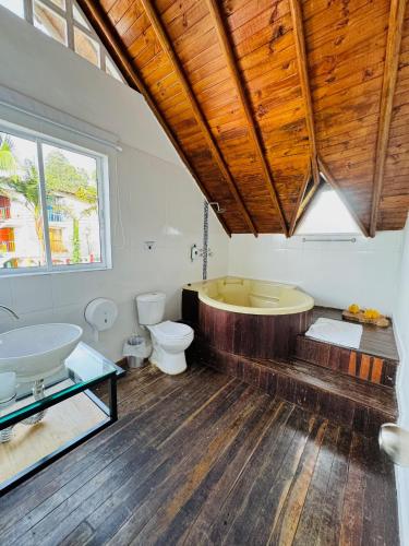 a bathroom with a tub and a toilet and a sink at La Madriguera in Guatapé