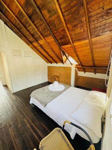 a bedroom with a large bed with a wooden ceiling at La Madriguera in Guatapé