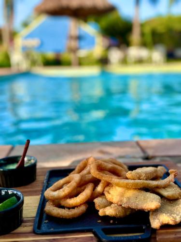 a plate of onion rings next to a swimming pool at Parque Hotel Holambra in Holambra