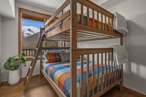a bunk bed in a room with a mountain view at Spring Creek Luxury at Exclusive Timberstone Lodge in Canmore