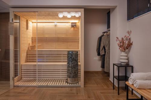 a walk in shower in a room with a closet at IRA - ΗΡΑ Hotel in Kalamata