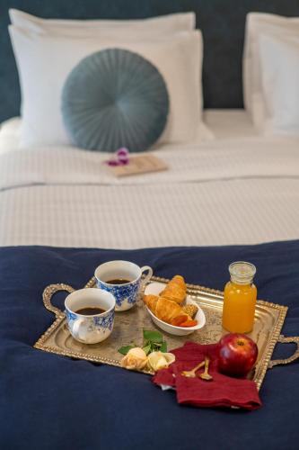 a tray of food and two cups of coffee on a bed at IRA - ΗΡΑ Hotel in Kalamata