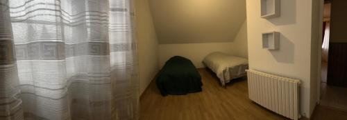 Cette petite chambre comprend un lit et un rideau. dans l'établissement Maison meublée, à Bourges